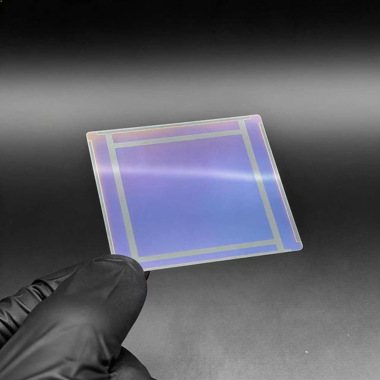 Ultra-thin cover glass sample held by a gloved hand