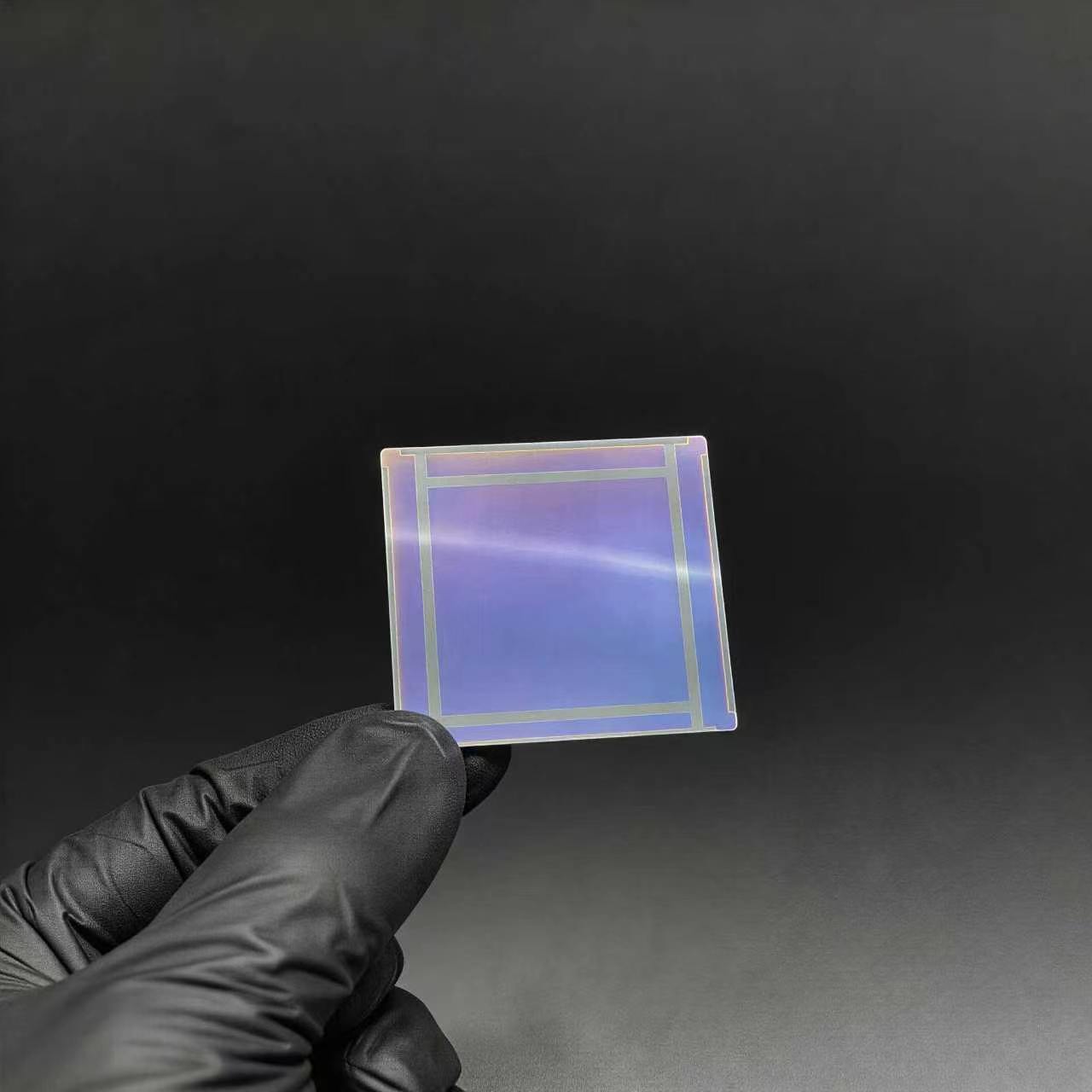 Ultra-thin cover glass sample in a gloved hand